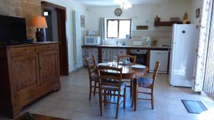 La cuisine est équipée d'une table, de chaises et d'un réfrigérateur. dans l'établissement LE POULAILLER DE LA CHAYRIE, à Lacapelle-Marival