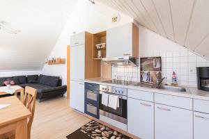 a kitchen with a sink and a stove top oven at Ferienwohnung Lauser Dg in Herdwangen-Schönach