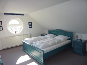 sypialnia z niebieskim łóżkiem i oknem w obiekcie Darsser Weg w Zingst