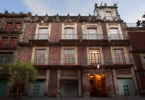 メキシコシティにあるHotel MX centroの窓とバルコニー付きの古いレンガ造りの建物