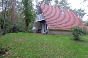 una pequeña casa con techo rojo en un patio en Vakantiehuis op top locatie #Ommen, en Ommen