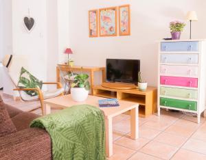 a living room with a couch and a table with a tv at Apartamentos Villamor in Denia