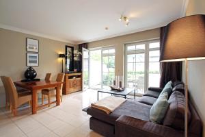 a living room with a couch and a table at Wellnessresidenz Klaus Stoertebeke in Zingst