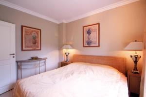 a bedroom with a white bed and two lamps at Wellnessresidenz Klaus Stoertebeke in Zingst
