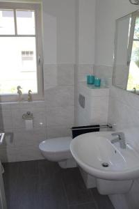 bagno bianco con lavandino e servizi igienici di Kavelweg 13 Kavella a Zingst