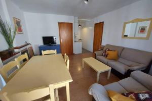 ein Wohnzimmer mit einem Tisch und einem Sofa in der Unterkunft Casa Bihotz - Bonito y céntrico apartamento con garaje en Sallent in Sallent de Gállego