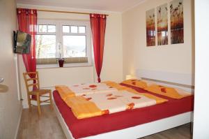 Schlafzimmer mit einem Bett mit roten Vorhängen und einem Fenster in der Unterkunft Hafenstr.35 Villa Verena in Zingst
