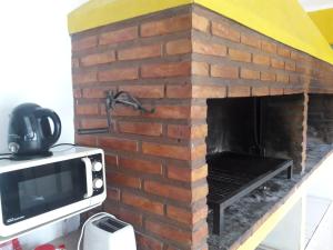 a brick fireplace with a tv on top of it at Apart Termal Centro in Termas de Río Hondo