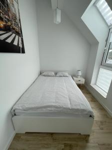 メヘリンキにあるBiały Klifの白いベッドルーム(ベッド1台、窓2つ付)