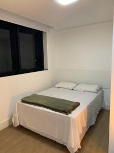 Un dormitorio con una cama con una manta verde. en 709- Apartamento Decorado Encantador, mobiliado, amplo, cozinha completa, Excelente localização no Rebouças en Curitiba