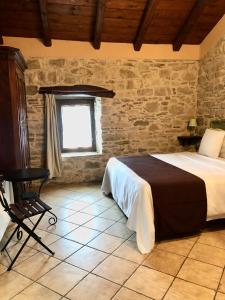 a bedroom with a bed and a chair and a window at Cascina Bertolotto Wine Resort in Spigno Monferrato