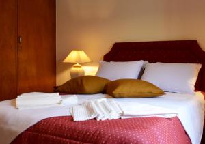 a large bed with pillows and towels on it at Batalhoz House in Cartaxo