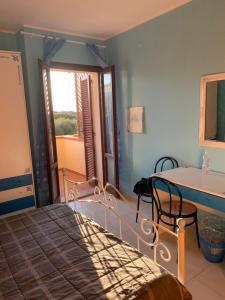 una camera con letto, tavolo e finestra di Casa accogliente a Calasetta