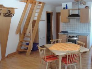 a kitchen with a table and a staircase in a room at Haus Gartnerkofelblick in Kirchbach