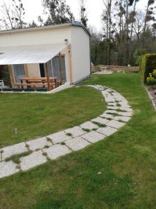 Una pasarela en un patio junto a una casa en Au cœur du jardin, en La Boussac