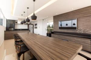 a large dining room with a large wooden table and chairs at 709- Apartamento Decorado Encantador, mobiliado, amplo, cozinha completa, Excelente localização no Rebouças in Curitiba