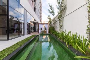 an internal courtyard with a pool in a building at 709- Apartamento Decorado Encantador, mobiliado, amplo, cozinha completa, Excelente localização no Rebouças in Curitiba