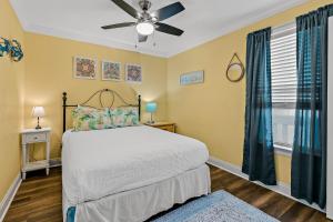 1 dormitorio con 1 cama y ventilador de techo en Hermitage, en Fort Walton Beach