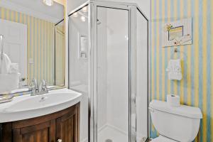 a bathroom with a toilet and a sink and a shower at Hermitage in Fort Walton Beach