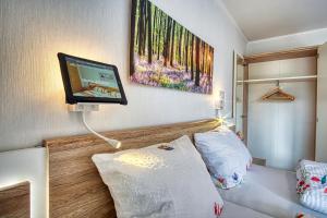 a room with a bed with a television on the wall at Dat lütte Heidehotel Funk - Garni in Bispingen