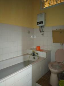 La salle de bains est pourvue d'une baignoire et de toilettes. dans l'établissement Guest House Syari'ah Sekar Manganti Mitra Aqsa, à Tjiamis