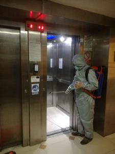 a person in a hazmat suit standing in an elevator at Hotel Panamericano in Lima