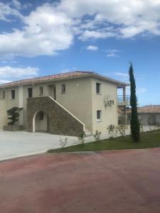 a large white building with a garage at Mare e Monti in Aléria