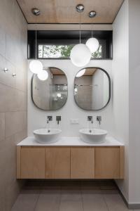 dois lavatórios numa casa de banho com dois espelhos em Shelest em Vyshhorod
