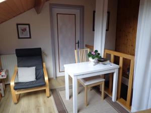 Zimmer mit einem Tisch, 2 Stühlen und einer Tür in der Unterkunft Le Chant du Merle in Neufchâteau