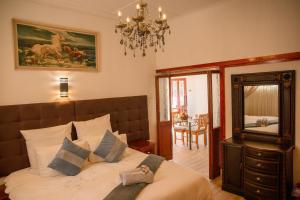Lincoln Cottages BnB & Self-Catering في بيترماريتزبورغ: غرفة نوم بسرير ومرآة وثريا +65 صورة