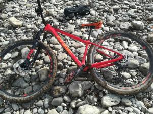 Una bicicleta roja sobre un montón de rocas en Agriturismo Le Chicche di Mafalda, en Montemerano