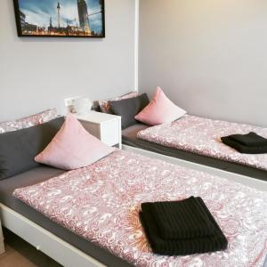 two beds in a room with pink pillows at Apartment mea in Berlin