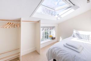 a bedroom with a white bed and a skylight at Abigail's Cottage, Wickham Market in Woodbridge