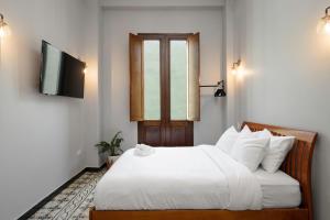 a bedroom with a white bed and a window at El Colonial Hotel Open Bar Adults Only in San Juan