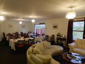 a living room with tables and couches and a dining room at Clunebeg Lodge in Drumnadrochit