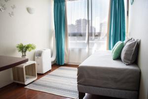 um quarto com uma cama com cortinas azuis e uma janela em Sweet Stay Chile em Santiago