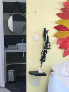 Schlafzimmer mit einem Bett, einem Waschbecken und einem Spiegel in der Unterkunft Piña Colada à Manapany les bains in Manapany-les Bains