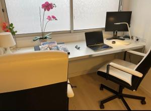 einen Schreibtisch mit einem Laptop und einem Stuhl in der Unterkunft White House Medano in El Médano