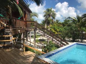 a house with a swimming pool and a wooden deck at The Tranquila Caye- Gold Standard Certified in Caye Caulker