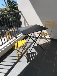 2 Stühle und ein Tisch auf dem Balkon in der Unterkunft Piña Colada à Manapany les bains in Manapany-les Bains