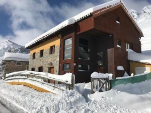 un edificio cubierto de nieve con nieve alrededor en Alojamientos Casa San Habitaciónes en Besande