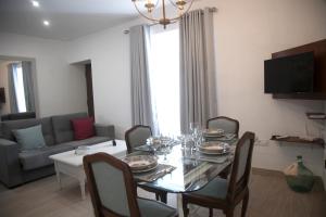 a dining room with a table with chairs and a couch at CASA CALLE EL CID in Medina Sidonia