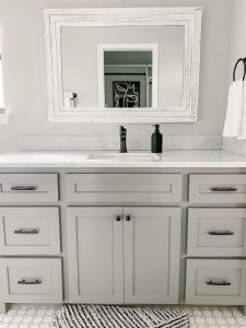 a bathroom with a white sink and a mirror at The Pearl: A Fully Updated 3 Bedroom Home Near ACU in Abilene