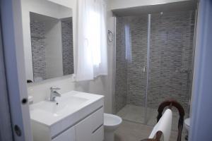 a white bathroom with a sink and a shower at CASA CALLE EL CID in Medina Sidonia +1 photo