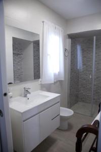 a bathroom with a sink and a toilet and a shower at CASA CALLE EL CID in Medina Sidonia