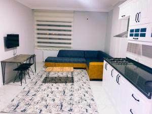 een woonkamer met een blauwe bank en een tafel bij Kılıç apart otel in Dargeçit