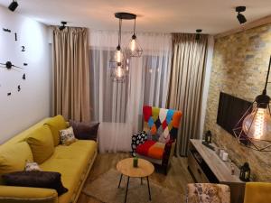 a living room with a yellow couch and a tv at Hedonic in Kopaonik