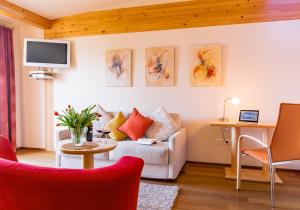a living room with a couch and a table at Das Moser - Hotel Garni am See (Adults Only) in Egg am Faaker See