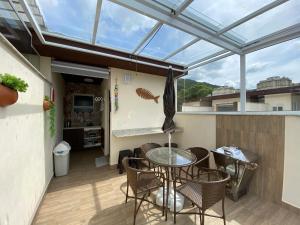a glass roofed patio with a table and chairs at Apto Novo Duplex em Juqhey in Juquei