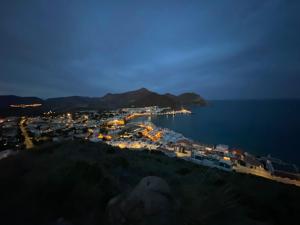 a view of a town at night with the ocean at Hostal Puerto Genovés in San José